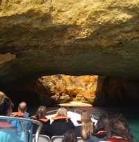 People on a small motorboat entering cave